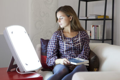 Woman using light therapy to treat seasonal depression